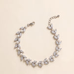 Miranda silver-finish bracelet arranged in a curve, showing paired leaf-shaped accents, round pearl-like details, lobster clasp and extension chain