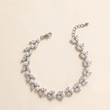 Miranda silver-finish bracelet arranged in a curve, showing paired leaf-shaped accents, round pearl-like details, lobster clasp and extension chain