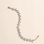 Miranda silver-finish bracelet with paired clear marquise-shaped leaves and round pearl-like accents, shown full length on a cream background