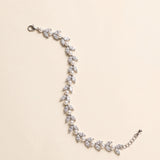 Miranda silver-finish bracelet with paired clear marquise-shaped leaves and round pearl-like accents, shown full length on a cream background