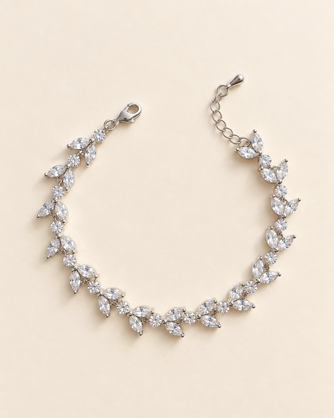 Vivienne silver-finish leaf-vine bridal bracelet with paired marquise-shaped and round clear accents on a cream background